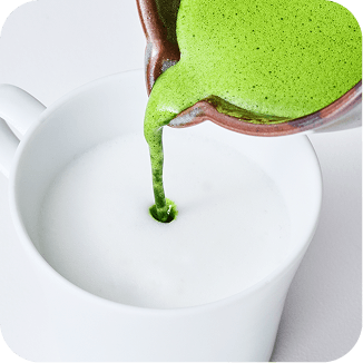 matcha being poured in a cup of milk